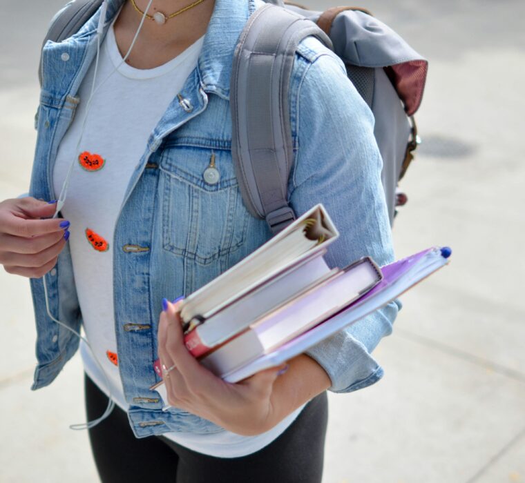 ragazza scuola superiore che porta dei libri in mano